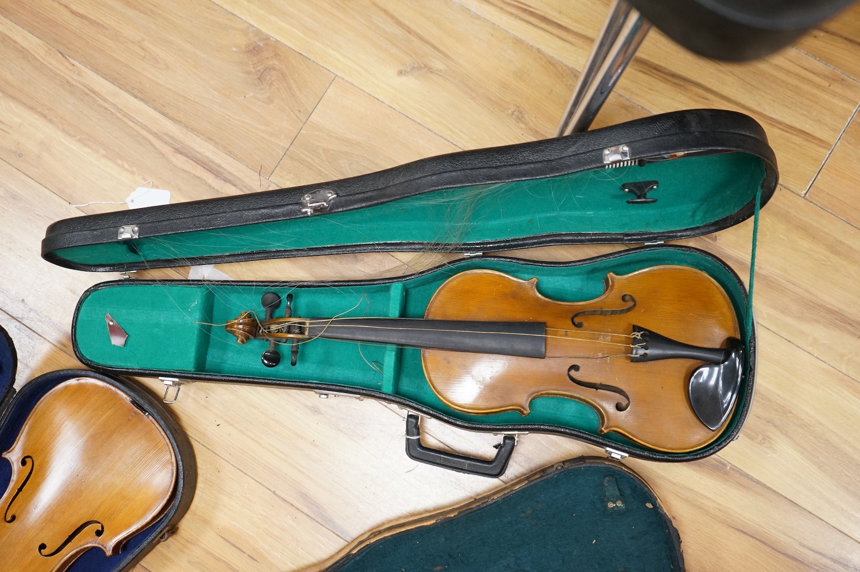 Three cased violins; a German Dresden violin, supplied by Campbell and co., Glasgow, together with another Dresden Stradivarius copy, and the remains of a European violin.